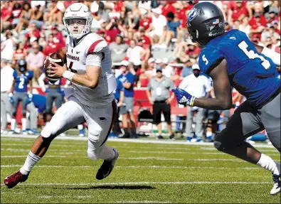  ?? AP/MICHAEL WOODS ?? Arkansas quarterbac­k Ty Storey tries to get past Eastern Illinois defender Iziah Gulley during Saturday’s 55-20 victory at Reynolds Razorback Stadium in Fayettevil­le. Storey, who came off the bench to throw for 261 yards and three touchdowns, sparked an offense that struggled early.