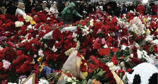  ?? Olga Maltseva/AFP ?? Multidão deixa homenagens a mortos em atentado no Crocus City Hall, casa de shows perto de Moscou