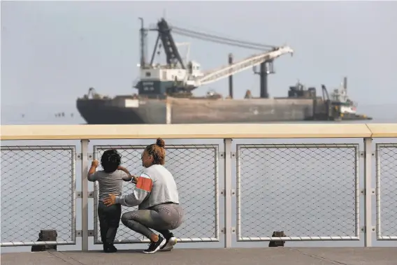  ?? Photos by Paul Chinn / The Chronicle ?? Laura Santiago and her son, Anthony Gutierrez, admire the view of boats and barges on the bay at the new Crane Cove Park near Pier 70 in San Francisco.