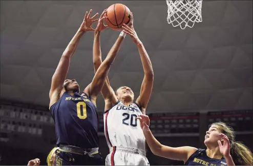  ?? Jessica Hill / Associated Press ?? Notre Dame’s Maya Dodson (0) and UConn’s Olivia Nelson-Ododa vie for a rebound in the first half Sunday in Storrs.