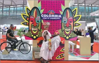  ?? ZHANG WEI / CHINA DAILY ?? A woman from Colombia performs at the 24th World Routes forum in Guangzhou, Guangdong province, on Sunday. Exhibitors from more than 115 countries and regions are attending the three-day event.
