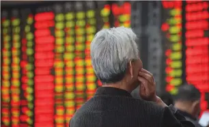  ?? (Reuters) ?? AN INVESTOR LOOKS at an electronic board showing stock informatio­n at a brokerage house in Nanjing, in China’s Jiangsu province, yesterday.