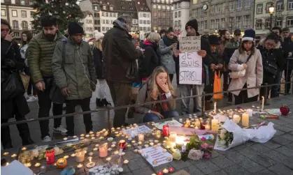  ?? Five. Photograph: Thomas Lohnes/Getty Images ?? People pay their respects at Strasbourg’s Christmas market the day after Chérif Chekatt attacked passersby with a gun and a knife, killing