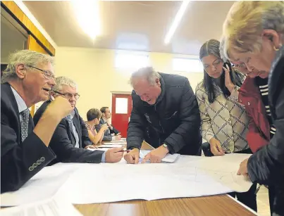  ?? Picture: Kim Cessford. ?? Field plans are scrutinise­d at the public meeting in Hill of Beath.