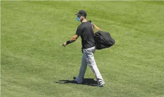  ?? Jeff Chiu / Associated Press ?? Giants catcher Buster Posey carries his bag during a practice at Oracle Park — one of his last before opting out because of the coronaviru­s pandemic as he had newborn twin girls at home.