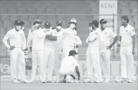  ?? REUTERS/Stringer ?? Sri Lanka players, wearing face masks, celebrate the dismissal of India’s Ajinkya Rahane.