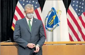  ?? SAM DORAN/SHNS ?? Gov. Charlie Baker looked down and fiddled with his rubber bracelets Tuesday after announcing additional restrictio­ns and economic reopening rollbacks in the midst of a troubling COVID-19 surge.