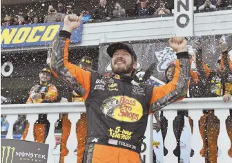  ?? AP PHOTO ?? REELING IN A WINNER: Martin Truex Jr. celebrates with teammates after winning the NASCAR Cup Series race at Pocono Raceway yesterday in Long Pond, Pa.