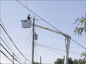  ?? MIKE CAMPBELL / STAFF ?? Crews work on repairing damage from this weekend’s storms on Bauer Avenue in Kettering.