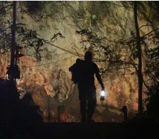  ??  ?? In this July 4, file photo, a rescuer makes his way down the entrance to a cave complex where 12 boys and their soccer coach went missing in Mae Sai, Chiang Rai province, northern Thailand.AP PhoTo/SAkchAI lAlI