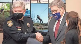  ??  ?? U.S. Attorney General William Barr, right, shakes hands with Memphis Police Department Deputy Director Mike Ryall before speaking at Ridgeway. Barr blamed the media for what he called a “false narrative” of bad police officers.