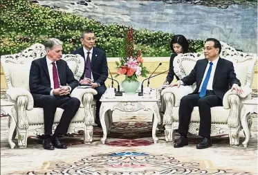  ??  ?? Better ties: Li speaking to Hammond at the Great Hall of the People in Beijing. — AP