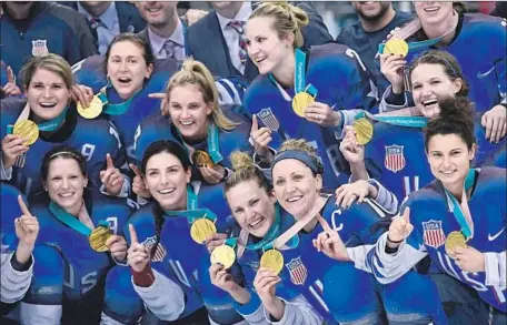  ?? Brendan Smialowski AFP / Getty Images ?? THE GOLD-MEDAL-WINNING U.S. WOMEN’S hockey team shows off its hardware after beating nemesis Canada in a shootout at the Pyeongchan­g Olympic Games at the Gangneung Hockey Centre. The U.S. victory ended Canada’s four-tournament winning streak.