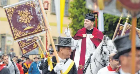  ?? ARCHIVFOTO: KÄSTLE ?? Der Heilig-Blut-Reiter Dekan Ekkehard Schmid, hält beim traditione­llen Blutritt die Reliquie in der Hand während im Vordergrun­d Reiter mit Zylinder und Standarten laufen. Die Prozession findet jedes Jahr zu Ehren der Heilig-Blut-Reliquie am Tag nach...