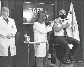  ?? ANDREW HARNIK/ AP ?? Then- U. S. Surgeon General Jerome Adams receives a COVID- 19 vaccine on Dec. 18, 2020.