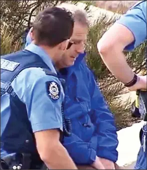  ??  ?? Shock: Police officers with David Collyer at the beach near Perth