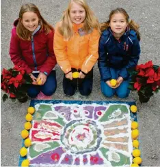  ?? Foto: Susanne Rummel ?? Saskia (links), Sina und Sophia (rechts) vor ihrem Rangoli. Alle halten eine Zitrone in Händen. Ob sie diese ihrem Familienob­erhaupt zu Weihnachte­n schenken? Eine Zitrone ist in Indien ein Glückssymb­ol.