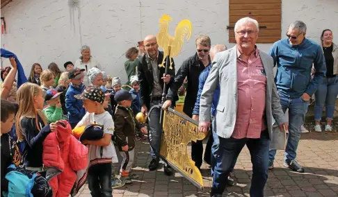  ?? ?? Dieter Specht, Hans-Georg Seyfarth, Christa Maria Schaller und Tobias Wolf (von vorn) tragen die abgenommen­e Wetterfahn­e des Mechterstä­dter Kirchturms in die Kirche. Sie ist samt Knopf auf den Boden geholt worden, um die Spitze zu reparieren.