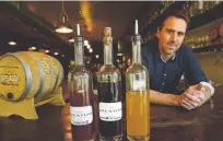  ??  ?? Elliot Strathmann, coowner of Spuntino, with his amari. From left: Aperitivo IV, All Colorado Amaro XV, and Saffron Liqueur.