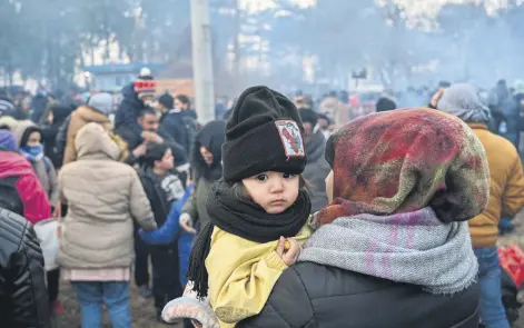  ??  ?? A child looks on as migrants wait to pass the buffer zone at the Turkey-Greece border, at Pazarkule, in Edirne district, Turkey, Feb. 29, 2020.