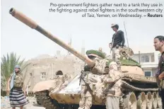  ?? — Reuters ?? Pro-government fighters gather next to a tank they use in the fighting against rebel fighters in the southweste­rn city of Taiz, Yemen, on Wednesday.