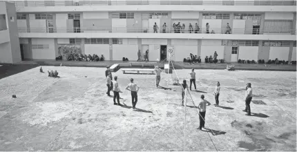  ?? PHOTOS BY CARRIE COCHRAN/USA TODAY NETWORK ?? Students play volleyball in the courtyard of Escuela Superior José Campeche. The building escaped major storm damage, but all through the school are reminders of Hurricane Maria’s destructio­n.