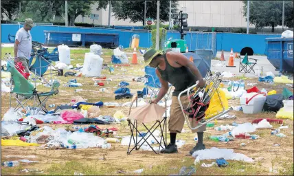  ?? JOE BURBANK/ORLANDO SENTINEL ?? City of Orlando workers clean up at Camp Trump Wednesday where supporters staged to wait in line for the president’s Tuesday night rally outside the Amway Center in downtown Orlando, Florida.