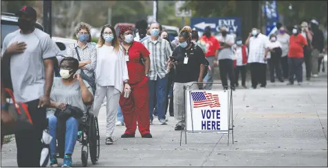  ?? (The Augusta Chronicle/Michael Holahan) ?? Voters wait in line to cast their ballot early at the Bell Auditorium in Augusta, Ga. Black people are going to the polls by the thousands and waiting in lines for hours to vote early in Georgia.