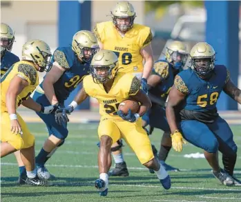  ?? MICHAEL LAUGHLIN/SOUTH FLORIDA SUN SENTINEL ?? St. Thomas Aquinas running back Jordan Lyle breaks through the defensive line during the Raiders’ spring game Thursday.