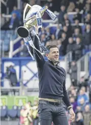  ?? ?? John Mousinho holds aloft the League One trophy