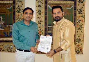  ?? Supplied photo ?? Dinesh Kumar presents a certified document authorisin­g MM Nasar Kanhangad to work with the local authoritie­s for repatriati­ing deceased Indians back home. —