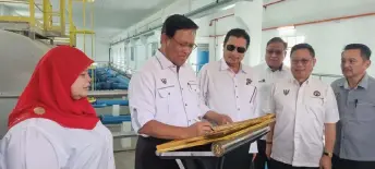  ?? ?? Dr Abdul Rahman signs a plaque to mark the official opening of the new booster pump station in Kota Samarahan. Looking on (front, from left) are Rubiah, Idris, Chang and others.