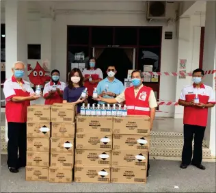  ??  ?? Chua (second right) symbolical­ly hands over hand sanitizer to Dr Teng (third left) while Lau (third right) and others look on.