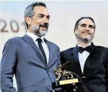  ?? BILD: SN/APA (AFP)/ALBERTO PIZZOLI ?? „Joker“-Regisseur Todd Phillips (links) freut sich mit Hauptdarst­eller Joaquin Phoenix über den Goldenen Löwen.