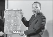  ?? HORACE CORT — AP FILE PHOTO ?? In this March 4, 1968 file photo, civil rights leader Rev. Dr. Martin Luther King, Jr., president of the Southern Christian Baptist Leadership Conference (SCLC), displays the poster to be used during his Poor People’s Campaign this spring and summer of 1968.