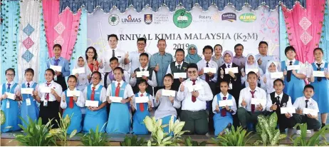  ??  ?? Penguang, flanked by Chan (back row, third left) and Seripah Azizah, joins the IKM scholarshi­p recipients and other guests in a group photo. Maria stands on the back row, at left.