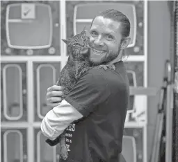  ??  ?? Danny Pintauro, a vet tech at Austin Pets Alive!, poses for a photo with a cat in Austin, Texas. Millions knew Pintauro as Jonathan Bower in the popular 1980s and 1990s TV series “Who’s the Boss,” in which he starred alongside Tony Danza and Alyssa Milano. The former child actor said he’s only now living out his true dream job – as a vet tech and cat care attendant at the Austin animal shelter.