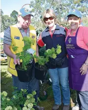  ??  ?? Yarragon Lions members Peter (left) and Alison Petschel (right) volunteer their services at last year’s services but also decided to buy some plants from Leanne Miller.