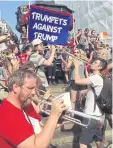  ??  ?? OUT OF TUNE: People play trumpets during a “Trumpets Against Trump” protest.