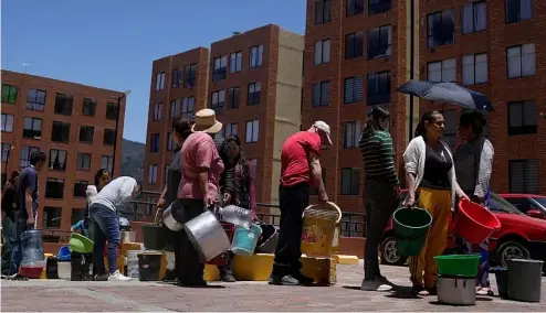  ?? ?? Residents line up to collect water from a truck during water rationing in La Calera, on the outskirts of Bogota, Colombia.