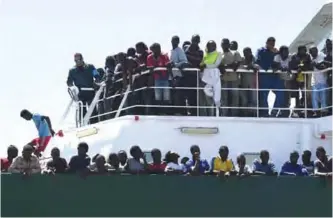  ??  ?? SALERNO: Migrants wait to disembark from the Spanish ship ‘Rio Segura’ in the harbor of Salerno, Italy. — AP