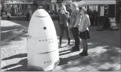  ?? STEVE MARCUS ?? Greg Copland and daughters Marissa, 16, left, and Anika, 15, look over a Knightscop­e security robot on Thursday at the Linq Promenade.