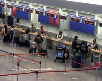  ?? BOSTON HERALD FILE ?? BE PREPARED: A few travelers wait at the check-in counter at Boston Logan Internatio­nal Airport on Sunday.