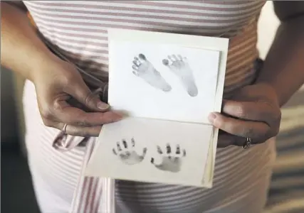  ?? Photograph­s by DANIA MAXWELL Los Angeles Times ?? CHRISTINA SHOWS her baby’s foot- and handprints after the procedure. Ending the pregnancy, she reasoned, was the only recourse — “the right thing to do for my baby, not for me. There was never a question that that’s not what that child deserved.”