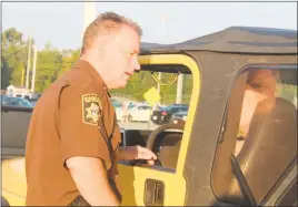  ?? STAFF PHOTOS BY JAMIE ANFENSON-COMEAU ?? Charles County Sheriff’s Office Lt. Randy Stine speaks to a driver about safe driving at La Plata High School Wednesday morning, as part of the “We Care” safe driving campaign.