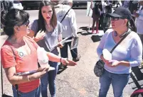  ??  ?? From left, Janet Aranda and Cameron Gonzales — daugher of Santa Fe Mayor Javier Gonzales — of PreK Santa Fe talk Monday with Jackie Flores during a May Day event about voting in favor of Santa Fe’s proposed soda tax.