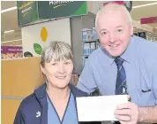  ?? 220218morr­isons_01 ?? Help for hospital Wester Moffat staff nurse Sharon Fagan receives cheque from Morrisons’ manager Jim Leghorn