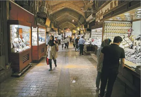  ?? Vahid Salemi Associated Press ?? IN TEHRAN, people visit a gold market at the Grand Bazaar last month. Iran’s currency has been losing more value against the dollar.