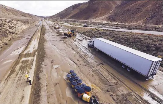  ?? Francine Orr Los Angeles Times ?? TRACTOR-TRAILERS sit stranded on Highway 58 near Tehachapi, where hundreds of vehicles were trapped, in some cases for hours, in up to 20 feet of debris.