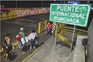  ?? AFP ?? A VENEZUELAN FAMILY crosses the Rumichaca Internatio­nal Bridge at the border of Ipiales in Colombia and Tulcan in Ecuador in this Aug. 23 photo.